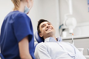 Patient smiling at dental assistant in treatment chair