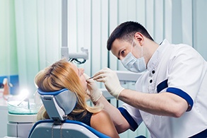 A young dentist working with a female patient